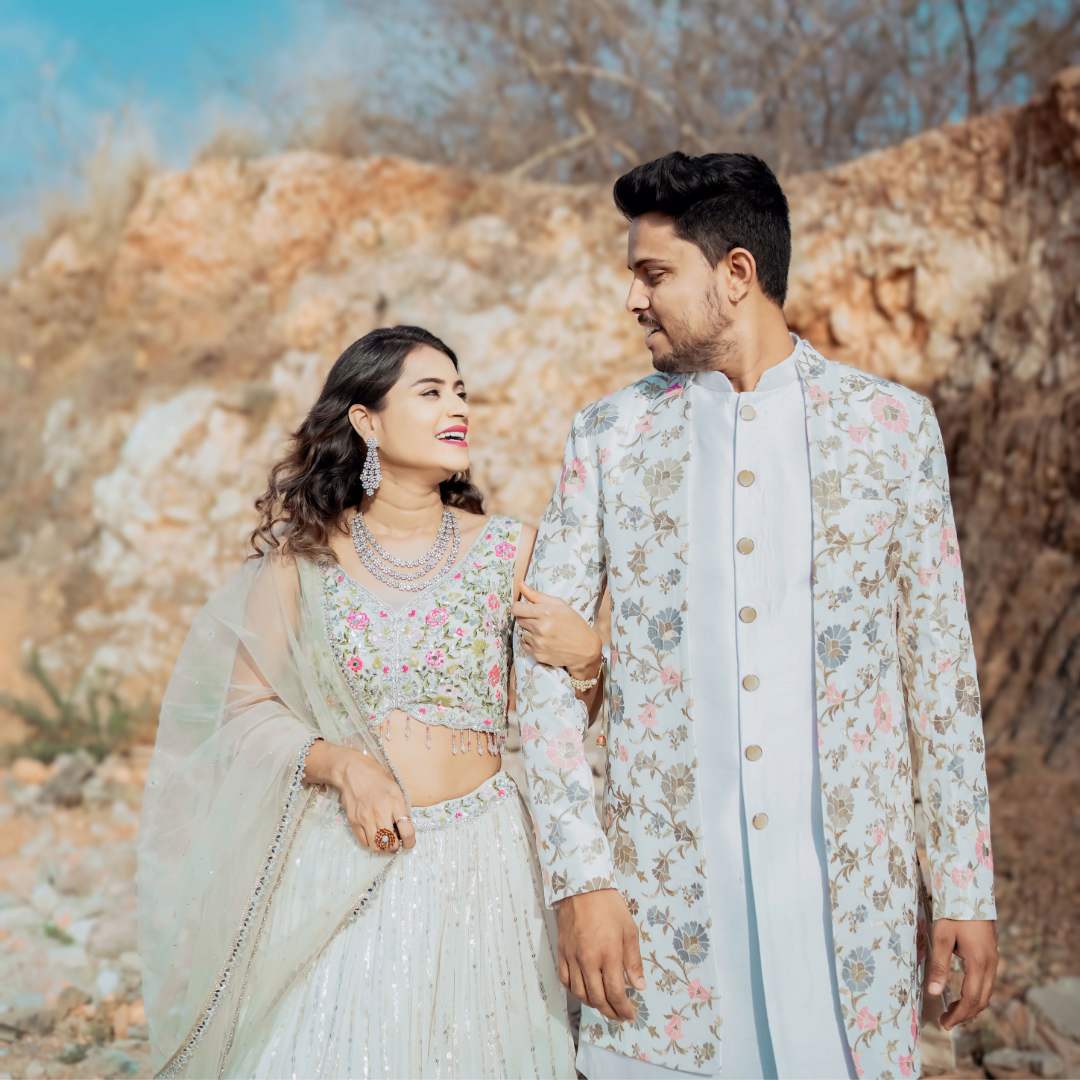 "Stylish couple outfit with coordinated Indo-western sherwani and lehenga."