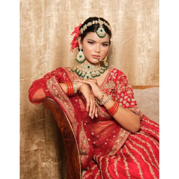 A stunning Red Silk Handworked Lehenga, intricately embroidered and displayed for rent at Fancyano in Udaipur, perfect for brides.