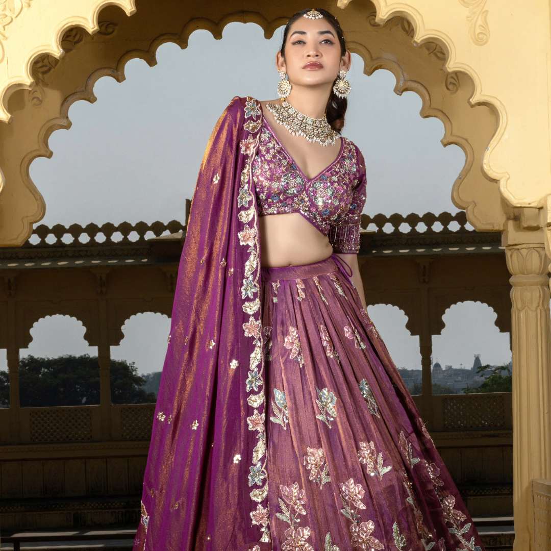 Bride wearing stylish purple crop top lehenga with hand-embroidered floral work in Udaipur