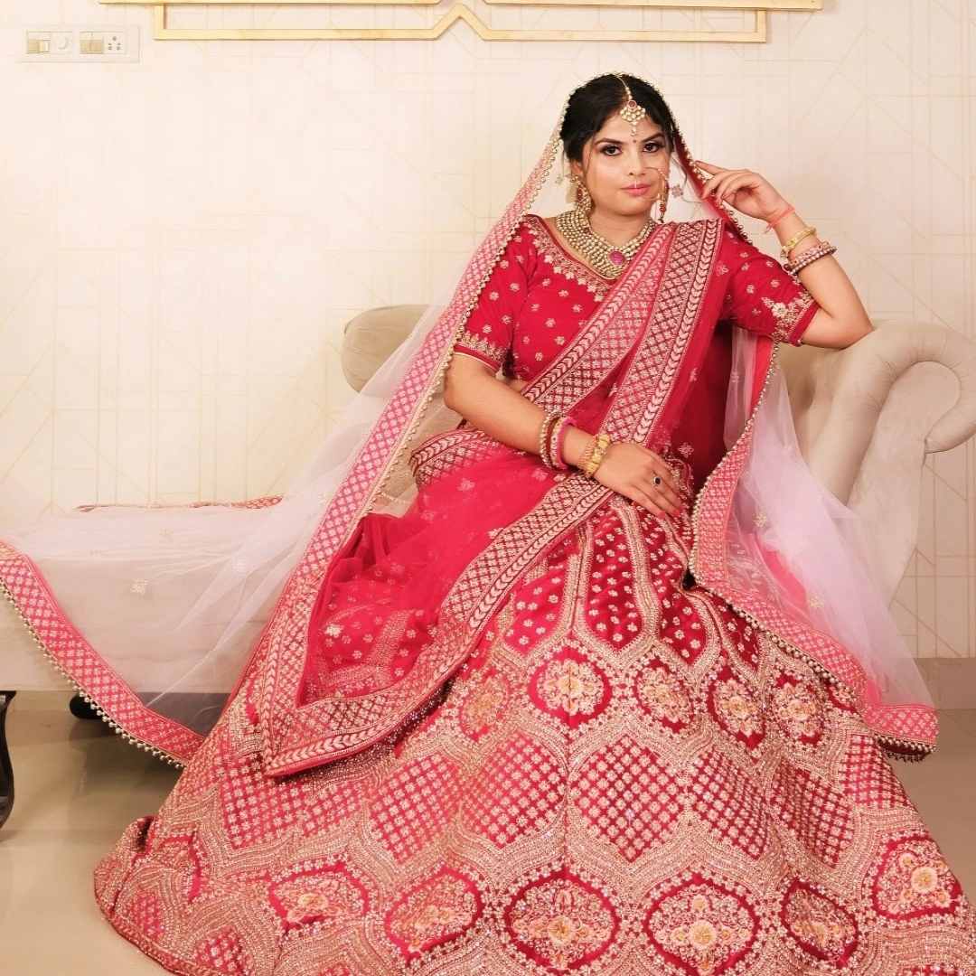 Bride in designer red bridal lehenga with golden embroidery – available on rent in Udaipur from Fancyano.